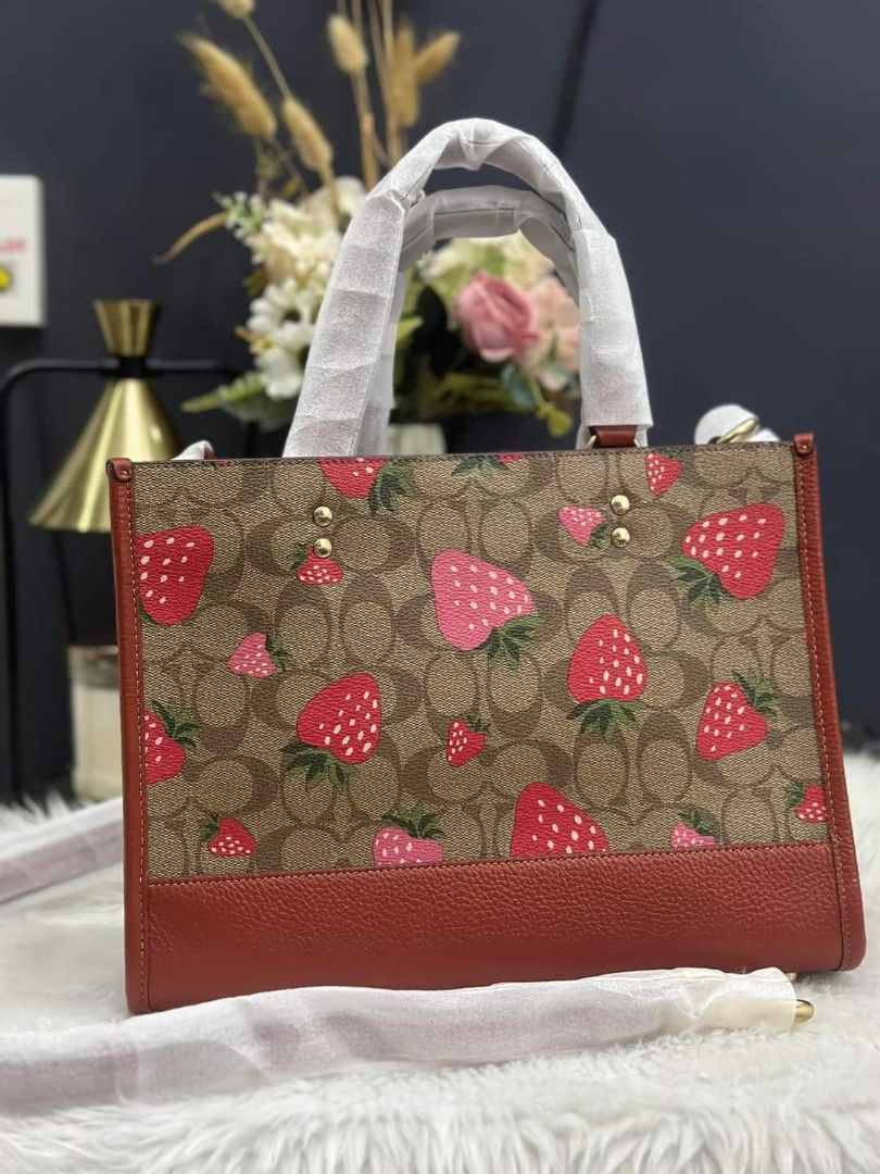 Coach sling bag (Category: Luxury Bags & Wallets) located in Cabanatuan. Submitted by Valeriecllctn (Listing ID 1248386666, Image 2). Description: Limited edition !!! Coach Dempsey strawberry print tote bag ₱9,999 only ZALORA price: ₱ 22,000 Layaway accepted ✅✅ Signature coated canvas and refined pebble leather Inside zip, cell phone and multifunction pockets Snap closure, fabric lining Handles with 5 1/4" drop Detachable strap with 20" drop for 