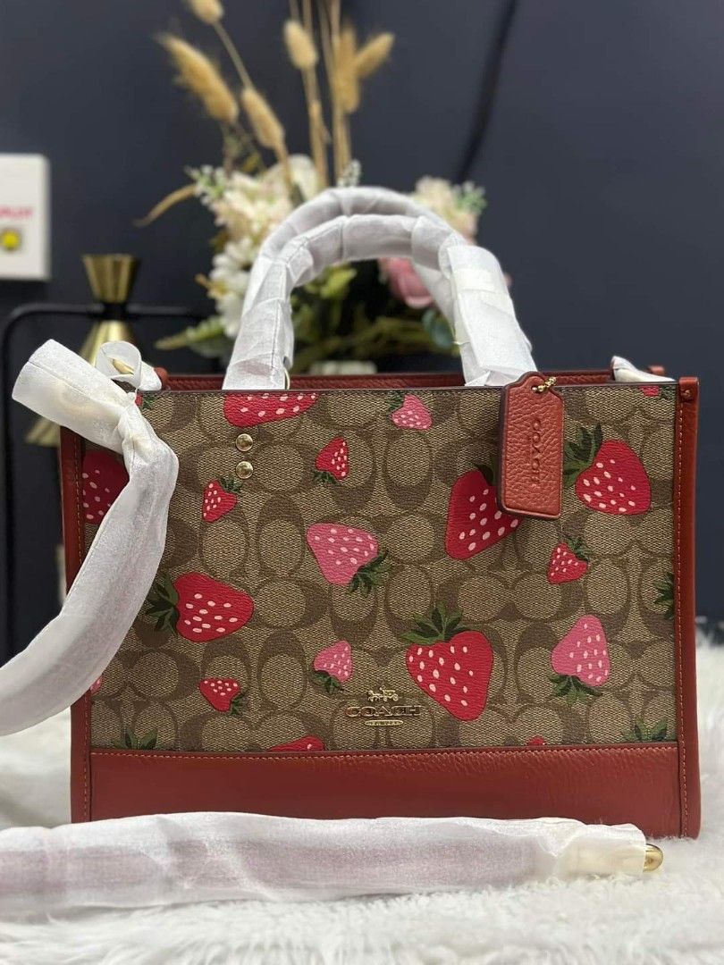 Coach sling bag (Category: Luxury Bags & Wallets) located in Cabanatuan. Submitted by Valeriecllctn (Listing ID 1248386666, Image 1). Description: Limited edition !!! Coach Dempsey strawberry print tote bag ₱9,999 only ZALORA price: ₱ 22,000 Layaway accepted ✅✅ Signature coated canvas and refined pebble leather Inside zip, cell phone and multifunction pockets Snap closure, fabric lining Handles with 5 1/4" drop Detachable strap with 20" drop for 