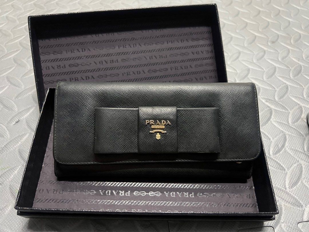 ₱r@d@ Saffiano Long Wallet (Category: Luxury Bags & Wallets) located in Quezon City. Submitted by pau.pm (Listing ID 1248665741, Image 2). Description: 📍Selling for Php9,000 📍Shipping from Brgy. Central, QC 📍MOP: BPI or Gcash This is an authentic Saffiano zip around wallet in black. This is a chic clutch wallet that is finely crafted of luxurious Saffiano cross-grain leather. The 3/4 wrap around zipper opens to a leather compact interior of zi