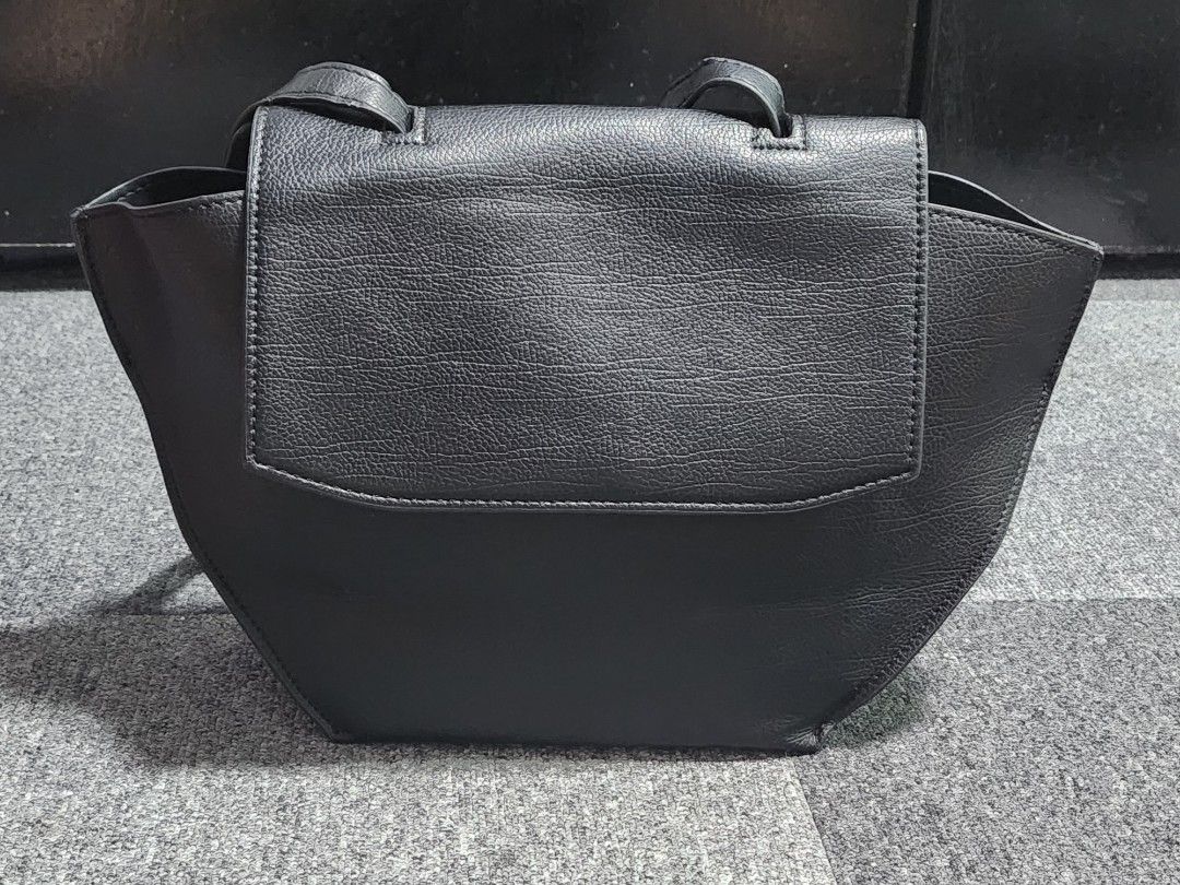 Charles and Keith Trapeze Top Handle Bag (Category: Shoulder Bags) located in Tarlac. Submitted by jemserrano (Listing ID 1249769711, Image 3). Description: Charles & Keith Trapeze Top Handle Bag • Black • Like new condition • Issue: Missing small handle, slight wrinkled long strap (see photos for reference) Dimensions: H - 9 inches L - 17 inches W - 4.5 inches ○ Shopee Checkout not available ○ Location📍 Tarlac ○ MOP: Gcash ○ Courier: J&T.