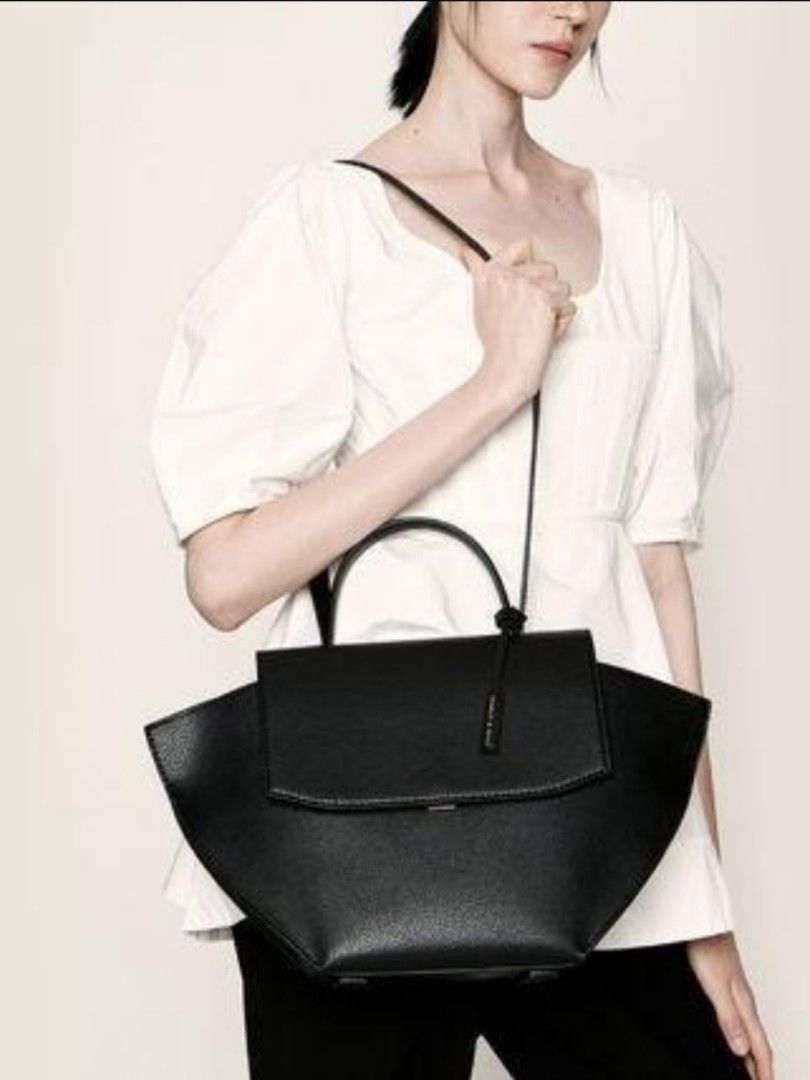 Charles and Keith Trapeze Top Handle Bag (Category: Shoulder Bags) located in Tarlac. Submitted by jemserrano (Listing ID 1249769711, Image 1). Description: Charles & Keith Trapeze Top Handle Bag • Black • Like new condition • Issue: Missing small handle, slight wrinkled long strap (see photos for reference) Dimensions: H - 9 inches L - 17 inches W - 4.5 inches ○ Shopee Checkout not available ○ Location📍 Tarlac ○ MOP: Gcash ○ Courier: J&T.