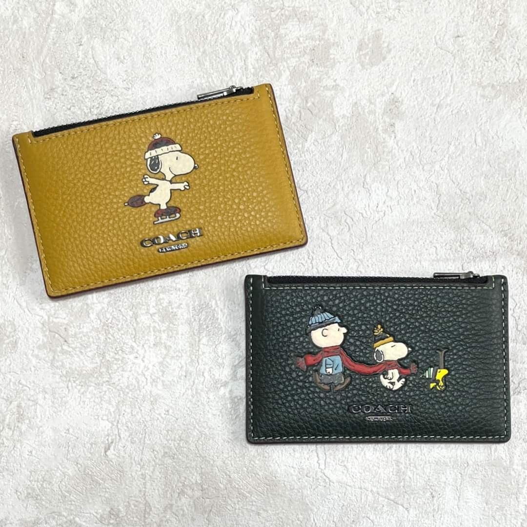 Coach X Peanuts Zip Card Case With Snoopy Motif (Category: Wallets & Card holders) located in Manila. Submitted by stacey_lopez922 (Listing ID 1247018928, Image 1). Description: Coach X Peanuts Zip Card Case With Snoopy Motif (With box and paperbag) - 5" (L) x 3 1/4" (H) - Refined pebble leather - Five credit card slots - Zip pocket.