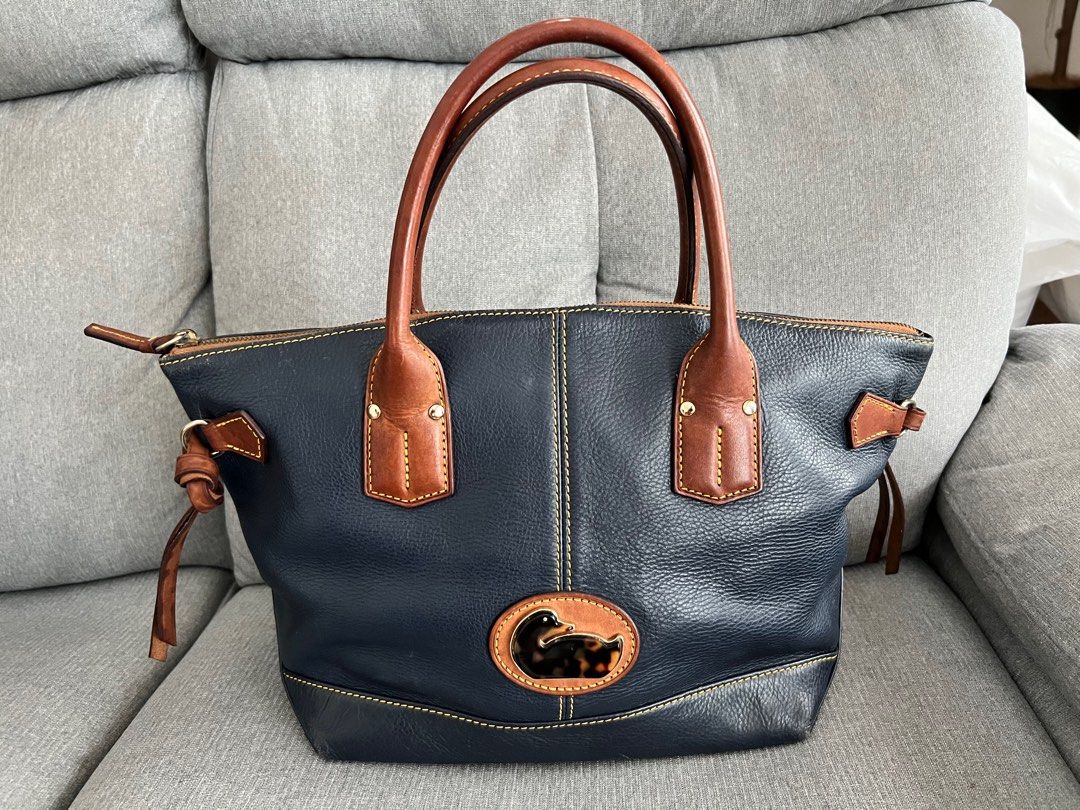 Dooney & Bourke Small Champosa Handbag (Category: Luxury Bags & Wallets) located in Makati City. Submitted by macypants (Listing ID 1247171684, Image 1). Description: Authentic Dooney & Bourke Small Champosa Handbag Navy and brown No inclusions Has some scratches on top handle, water marks on straps on sides, fading on bottoms corners and hairline scratches on body.
