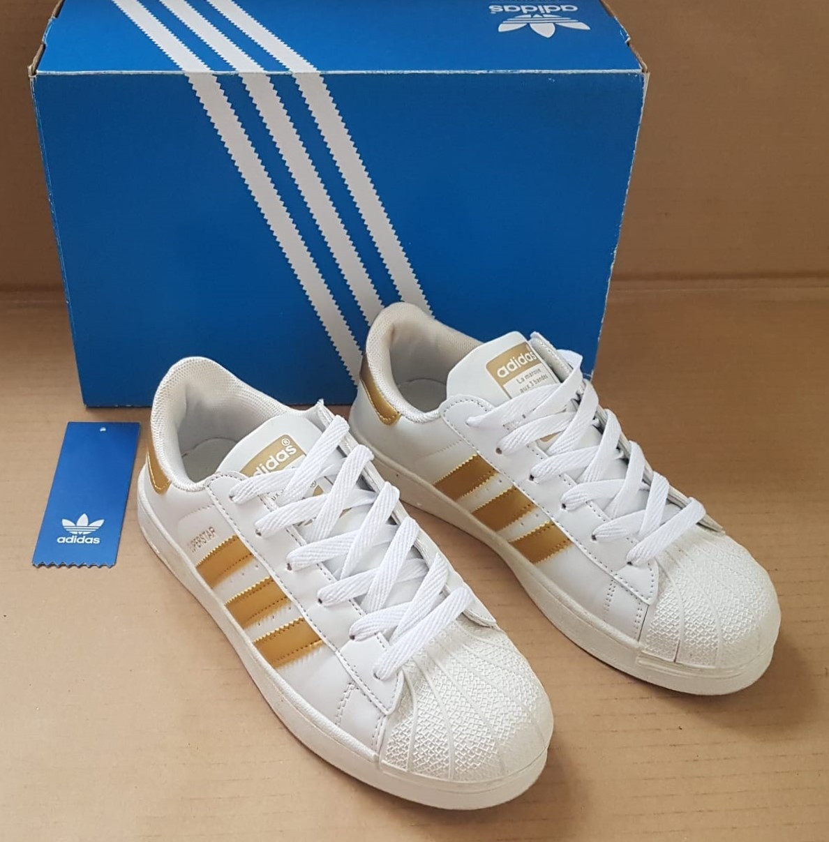 White adidas with gold stripes cheap