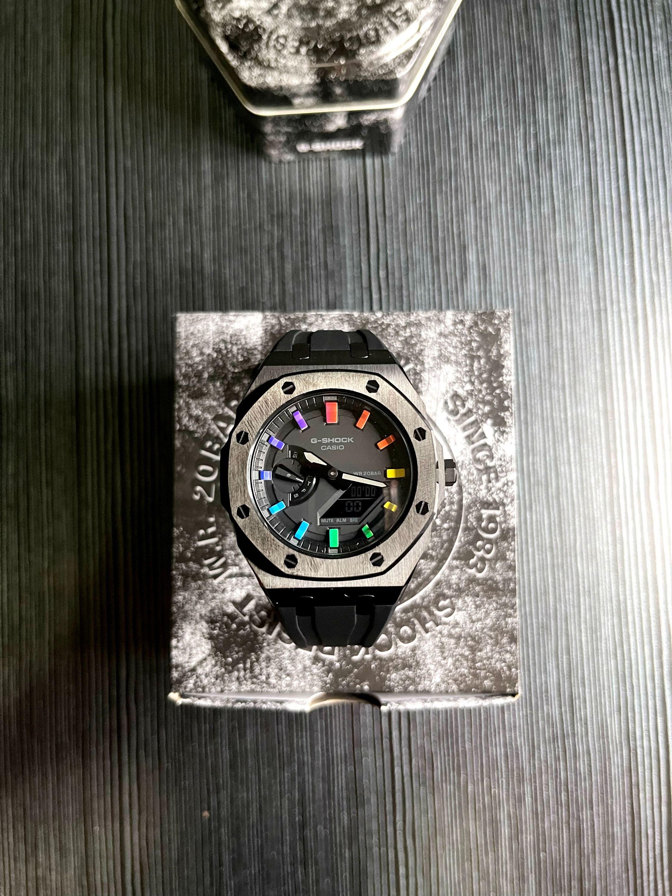 Casio G SHOCK Custom Royal Oak Casio Oak GA 2100 1A Black dial with Rainbow accent Black metal bezel with Black rubber strap and butterfly clasp
