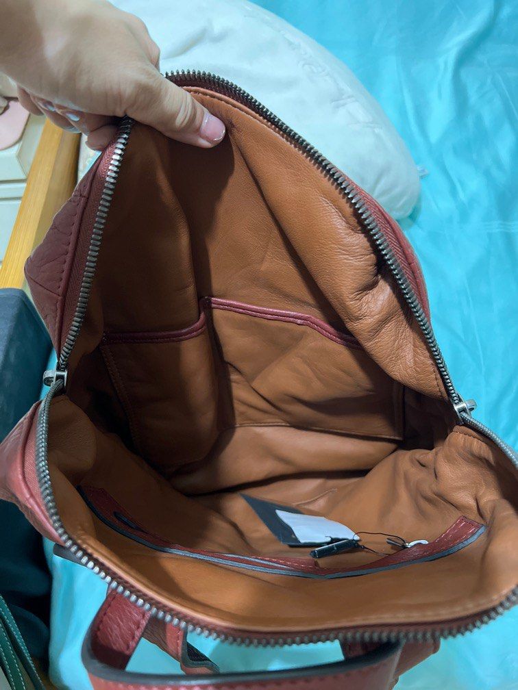 Backpack (Category: Bags & Wallets) located in Singapore. Submitted by pinkdancer (Listing ID 1257153793, Image 3). Description: Brand new with tag. the straps r brand new and not strapped through the hooks yet. Smell of leather still there. Able to hit 13-15 inch laptop, very spacious n good leather. Great for daily use or travel!.