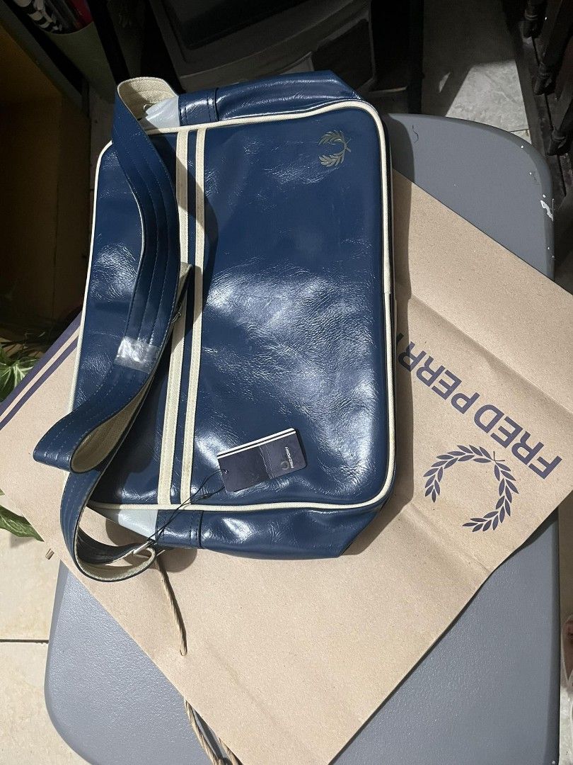 Authentic Original Fred Perry Classic Shoulder Bag navy blue (Category: Luxury Bags & Wallets) located in Quezon City. Submitted by the_firm888888 (Listing ID 1257532056, Image 1). Description: Fred Perry Classic Shoulder / laptop Bag QC area - For meetups: SM North Edsa - Also available for Grab / Lalamove (shipping not included, buyer shoulders shipping fee) - BRAND NEW, including original Fred Perry paper bag and straps. Never been used - 1 pe