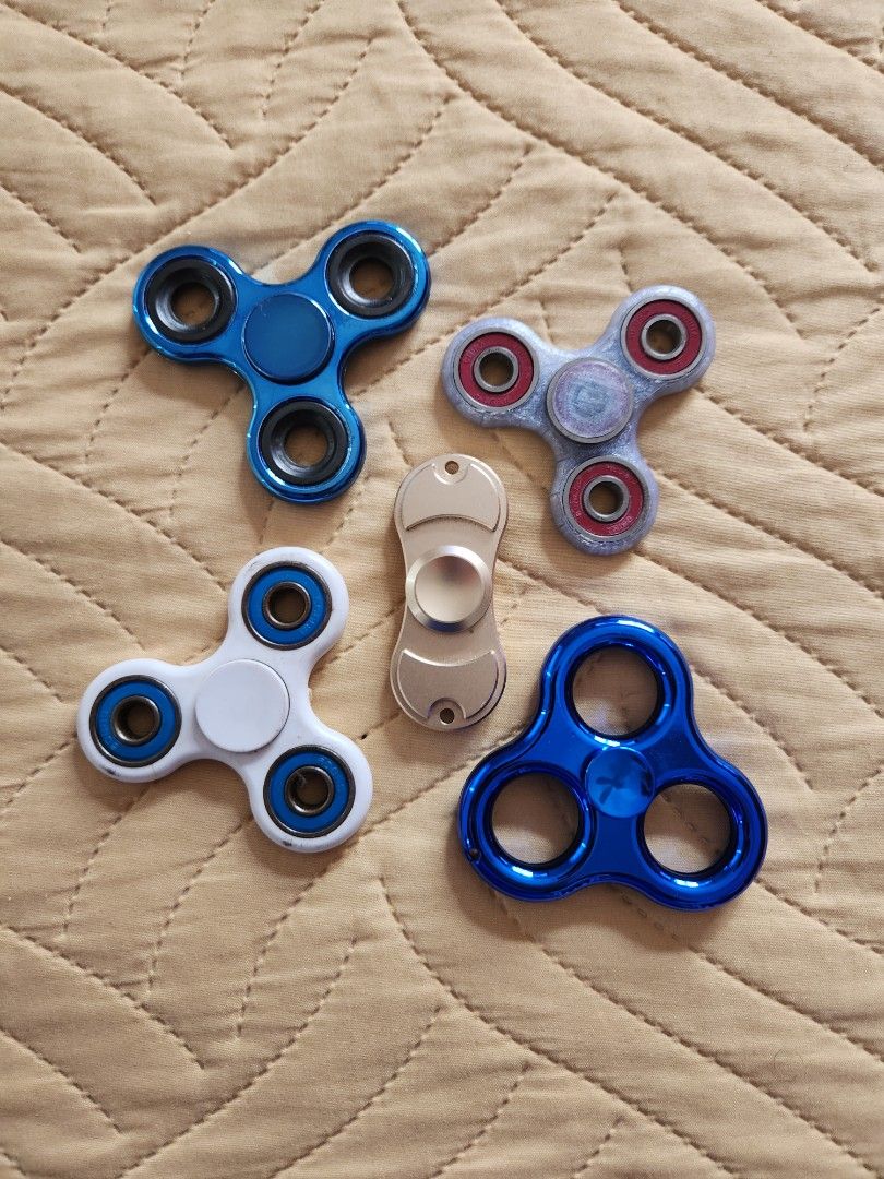 Assorted Fidget Spinners (Category: Action & Battle Toys) located in Pasig City. Submitted by ge_borro (Listing ID 1280097235, Image 1). Description: A. 3-point Blue - SOLD B. 2-point Gold - P300 C. 3-point White - SOLD D. 3-point 3D Printed - P180 E. 3-point Blue (Plastic) - SOLD all in good working condition, may have signs of use (scratches/paint defects).