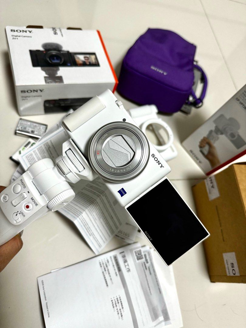 SONY WHITE ZV1 BUNDLE (barely used) (Category: Cameras) located in Manila. Submitted by msaudreybauza (Listing ID 1280059498, Image 2). Description: RFS : DECLUTTERING inclusions: ZV1 unit wireless sony grip GP-VPT2BT original sony battery 2 extra batteries battery charger adapter battery and sd card case Limited edition sony ZV1 Violet bag Complete manual Box and paperwork originall receipt 2 mountable deadcats.