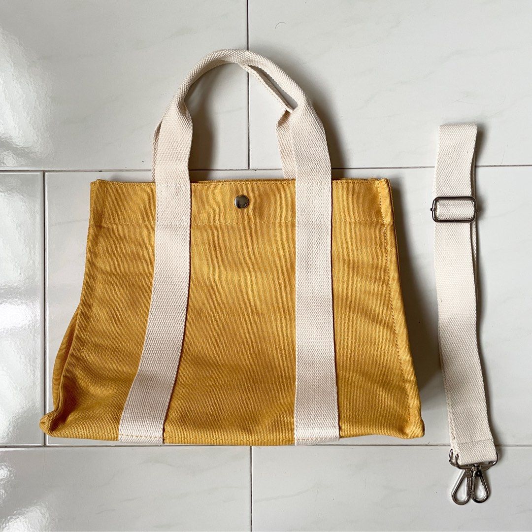Off white purse with yellow sales strap
