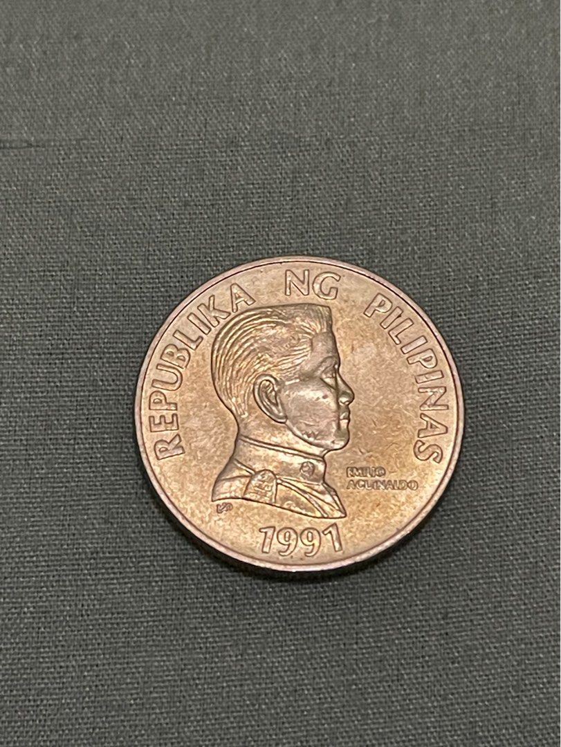 5 piso 1991 error coin (Category: Currency) located in Valenzuela. Submitted by eternallyblessed587 (Listing ID 1276027981, Image 1). Description: This 1991 Philippine 5-peso coin in very good condition has very noticeable obverse errors with 3 almost identical indented markings right in the mid jawline. .