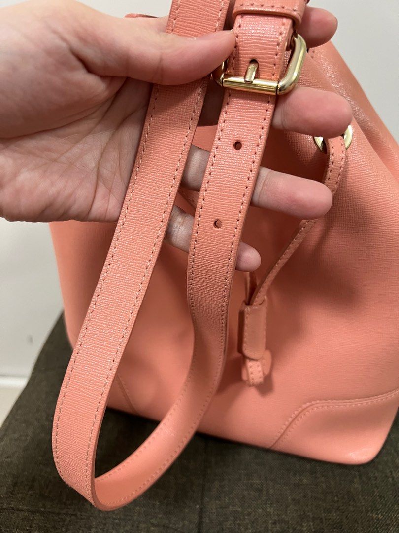 Furla Bucket Bag (Category: Cross-body Bags) located in Taguig. Submitted by prelovedjoys19 (Listing ID 1276032079, Image 3). Description: Preloved Furla Bucket Bag Color: Salmon Pink — pretty in actual! Can be worn 2-ways (handbag or crossbody bag) Comes with care card and dustbag Well used condition With minimal stains, corner rubs, cracked and bobble on suede (inside) Location: Acacia Estates, Taguig.