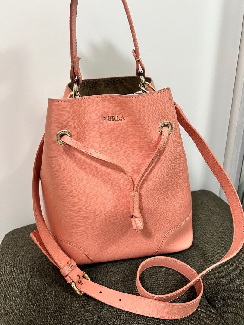Furla Bucket Bag (Category: Cross-body Bags) located in Taguig. Submitted by prelovedjoys19 (Listing ID 1276032079, Image 1). Description: Preloved Furla Bucket Bag Color: Salmon Pink — pretty in actual! Can be worn 2-ways (handbag or crossbody bag) Comes with care card and dustbag Well used condition With minimal stains, corner rubs, cracked and bobble on suede (inside) Location: Acacia Estates, Taguig.