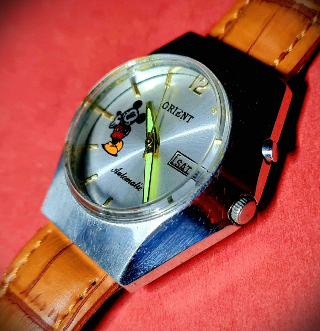 #Luxury Watch #Rare Unique #Mickey Mouse #Orient #Japan Made #Automatic (Category: Luxury Watches) located in Caloocan City. Submitted by allig8 (Listing ID 1282390680, Image 1). Description: This unique ORIENT Japanese Mickey Mouse watch boasts a stunning thick silvery case with a beautiful round shiny dial that features golden hour markers as indices. The 39mm case houses a reliable automatic movement with 21 jewels, ensuring accurate timekeepi