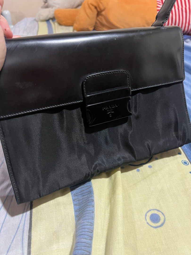 💯PRADA shoulder bag (Category: Luxury Bags & Wallets) located in Quezon City. Submitted by KK_declutterluxx (Listing ID 1282457607, Image 2). Description: Preloved Prada shoulder bag -authentic -small size pero kasya promax or big phone, maluwag pa - nylon body, leather flap -no cracks -mejo konti lukot ang nylon - yung lock as you can see meron ng scratches Pero no issue sa lock Overall nice 📍QC - sf c/o buyer Payment via bank xfer, EASTWEST b