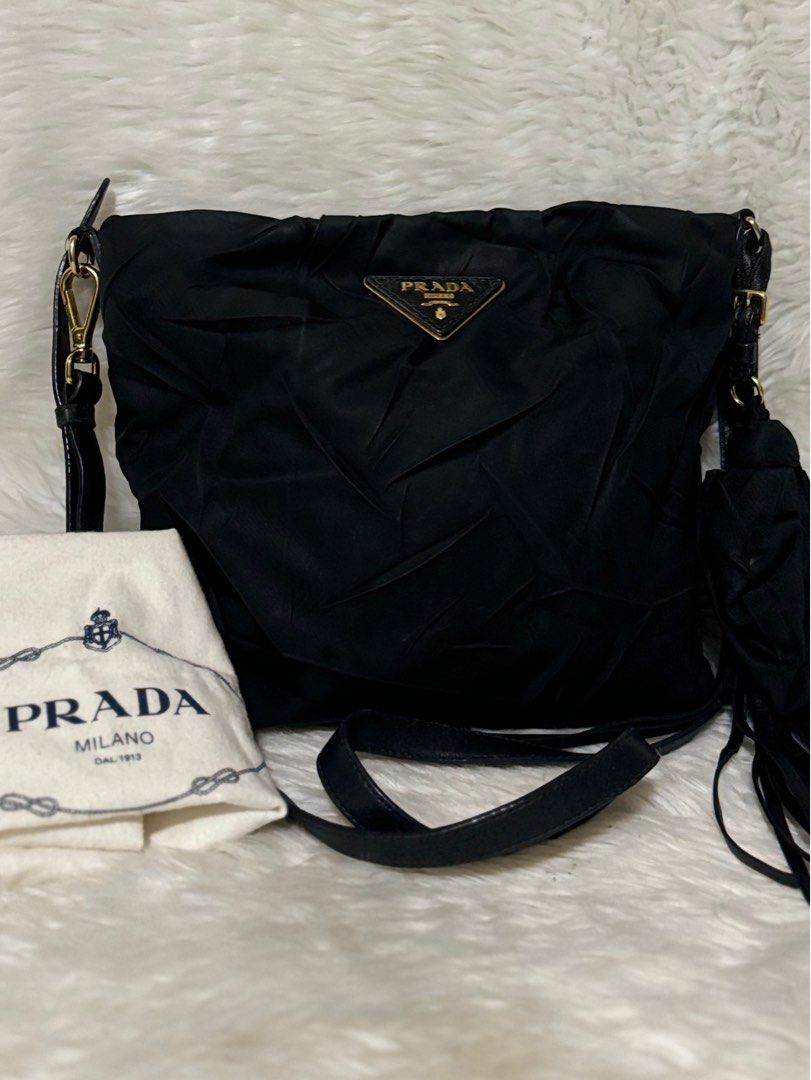Prada Sling Bag with Tassel (Stropicciato) (Category: Luxury Bags & Wallets) located in Cabanatuan. Submitted by bag_a_beau (Listing ID 1330151249, Image 1). Description: Prada Tessuto sling/crossbody bag, Wrinkled nylon with tassel, Black, adjustable and removable leather strap, tassel is removable, intact rubber lining but with minor cracks on leather strap, with dust bag, sourced from Japan Signs of use: minimal white cast on the exterior (unn