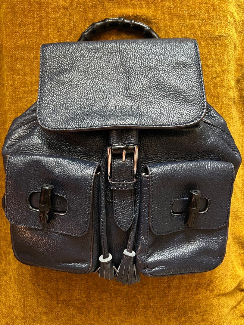 Gucci Bamboo Backpack (Category: Luxury Bags & Wallets) located in Manila. Submitted by ladybagmnl (Listing ID 1330344123, Image 1). Description: Inclusions: Generic Dustbag Material: Leather Color: Dark Blue Size: Base length: 12.00 in Height: 11.75 in This piece features cowhide leather exterior front pocket flaps with bamboo turn locks, cowhide shoulder straps, and a bamboo top handle with polished silver hardware. The top flap opens by tassel