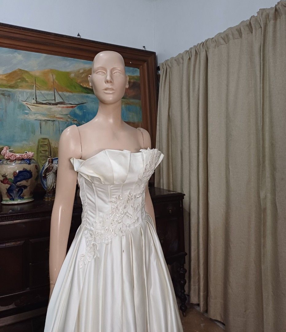 Elegant Mikado Wedding Gown (Category: Evening dresses & gowns) located in Carmona. Submitted by fashionlibraryph (Listing ID 1331678385, Image 2). Description: This stunning strapless wedding gown, made from luxurious Mikado fabric, showcases a dramatic and architectural straight-across neckline. The neckline features large, expertly crafted pleats that form a striking structured look, giving the gown a bold and sophisticated edge. These pleats 