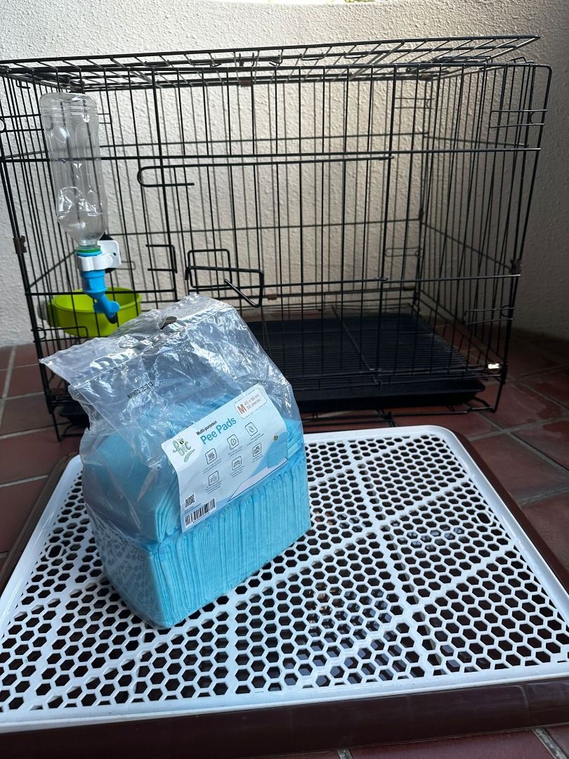 medium sized dog crate with food and water dispenser; pee tray and