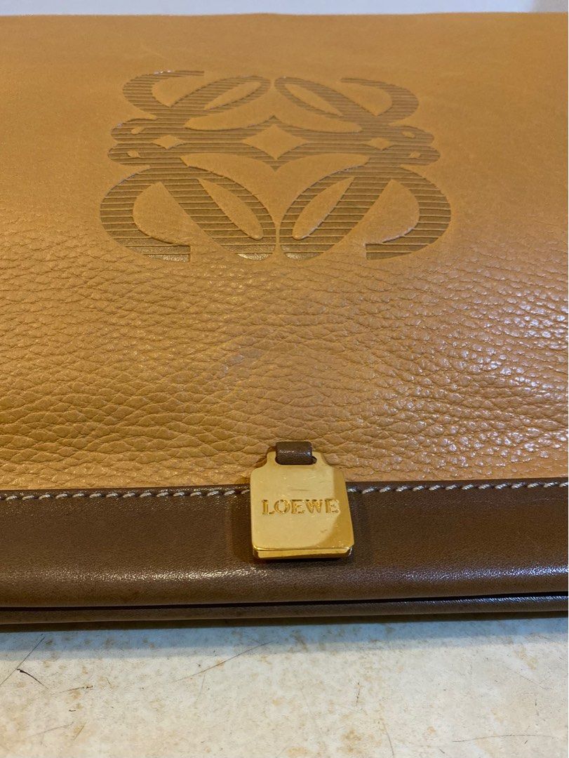 LOEWE Vintage Anagram Envelope Pouch (Category: Luxury Bags & Wallets) located in Manila. Submitted by lilyroseandlauretta (Listing ID 1328944896, Image 2). Description: LOEWE Vintage Anagram Embossed Envelope Pouch -pebbled leather -embossed logo -gold hardware -magnetic snap closure -cotton interior lining -dimension: 13 x 2.5 x 9.5 inches -made in Spain *NO INCLUSIONS *CONDITION vintage pre-owned good condition leather crease scrathes on the h
