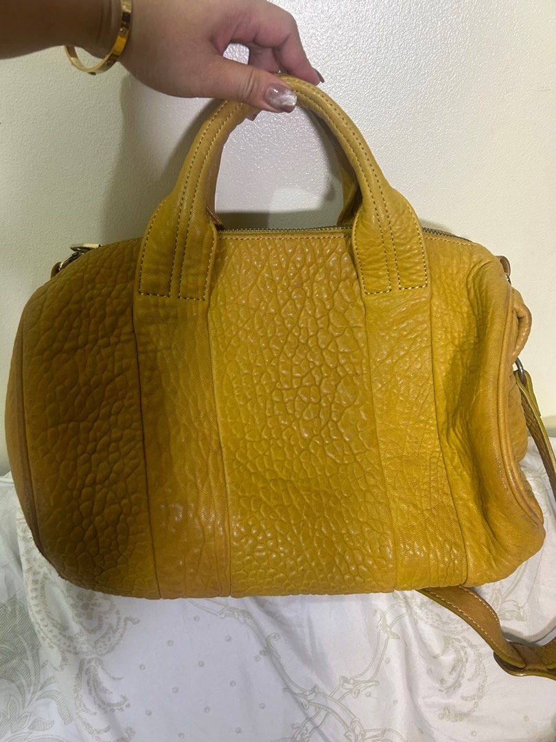RARE 💗 Alexander Mcqueen Speedy (Category: Luxury Bags & Wallets) located in Quezon City. Submitted by she-ann (Listing ID 1328968649, Image 1). Description: Authentic Alexander Wang speedy Bag PLEASE READ: 32cm base x 25cm height (roughly) 2 way bag Mustard yellow in color (medyo madumi na lang pero pwede naman malinisan) Gender friendly Siper nice in person May weight guys kasi mabigat yung mga metal sa ilalim Very spacious Soft leather Flaw: 