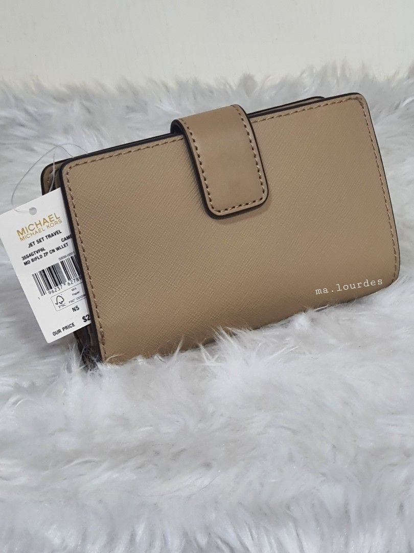 MK Jet Set Travel Medium Bifold Wallet 🇱🇷 (Category: Luxury Bags & Wallets) located in Quezon City. Submitted by rmlrluxfinds (Listing ID 1335696679, Image 2). Description: ** retail item ** in CAMEL color ** goldtone hardware ** front zip compartment ** back bifold compartment ** logo lining, 6 credit card slots, full-length bill compartment and clear ID window ** measures 5.25"L x 3.25"H x 1.25"D ON HAND and ready to ship ✅️tag ✅️carecard Dis