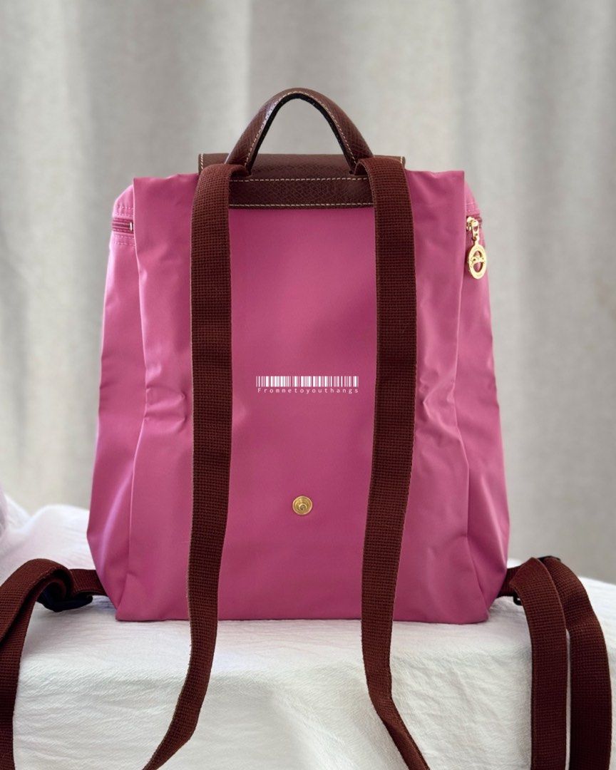 LONGCHAMP Le Pliage Backpack (Peony) (Category: Luxury Bags & Wallets) located in Cavite. Submitted by frommetoyouthings (Listing ID 1337432749, Image 2). Description: Excellent condition Discontinued seasonal colour Flaw/s: A bit of dirt on the interior of the bag and corner rubs. (Can be clean via DIY or a professional bag services. e.g Doctor Leather) Includes: care card Rustan's SRP: ₱9800.