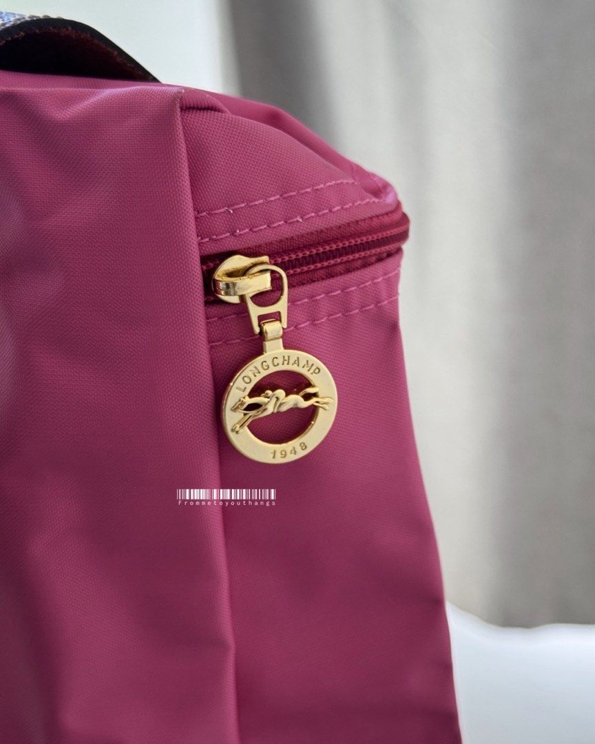 LONGCHAMP Le Pliage Backpack (Peony) (Category: Luxury Bags & Wallets) located in Cavite. Submitted by frommetoyouthings (Listing ID 1337432749, Image 3). Description: Excellent condition Discontinued seasonal colour Flaw/s: A bit of dirt on the interior of the bag and corner rubs. (Can be clean via DIY or a professional bag services. e.g Doctor Leather) Includes: care card Rustan's SRP: ₱9800.