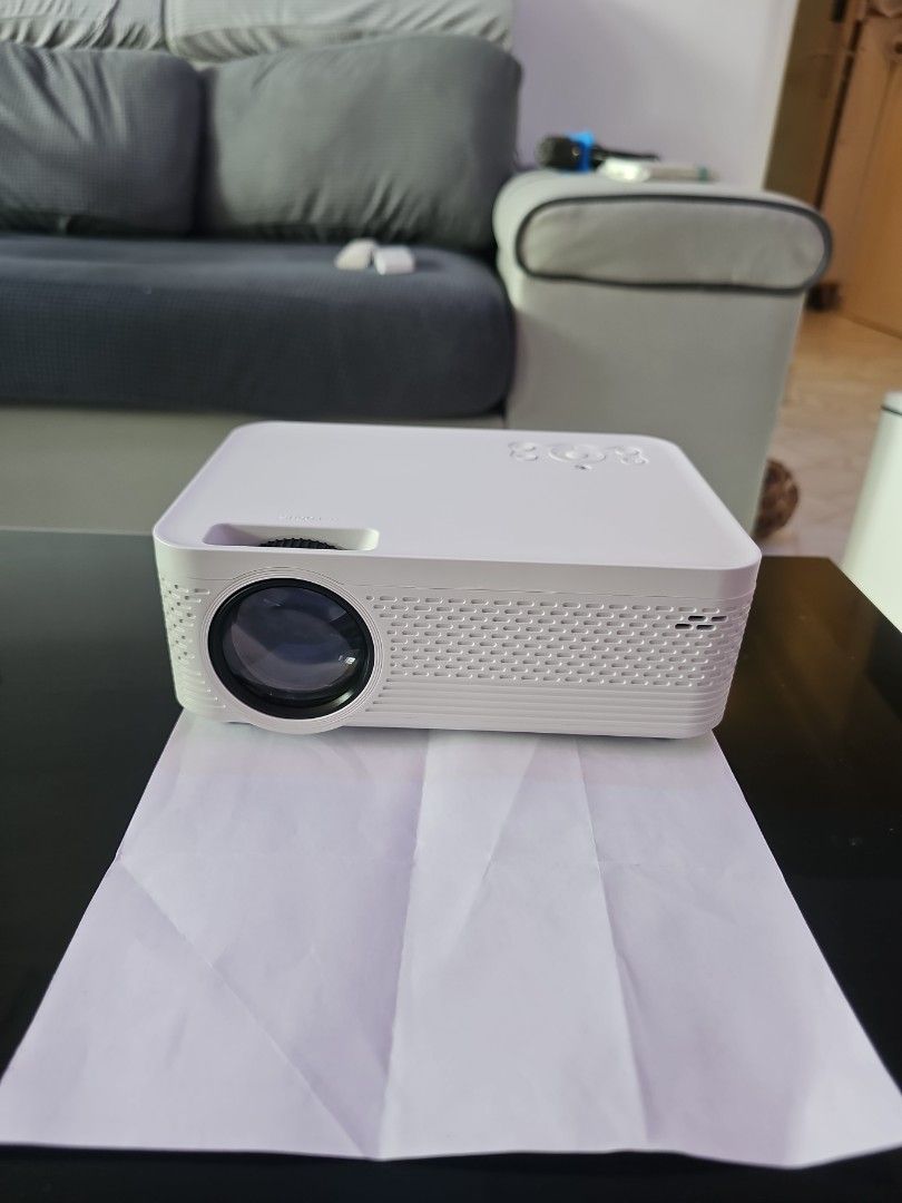 Projector (Category: Projectors) located in Singapore. Submitted by dorightbyu (Listing ID 1337497901, Image 2). Description: just opened to test but no space at home to use it properly. my lost your gain! Small size! half the size of A4 paper. original box intact comes with screen cloth to allow daylight viewing. Has inbuilt China apps like Mango TV etc that has free content inside. non global version has microSD slots. No HDMI port.