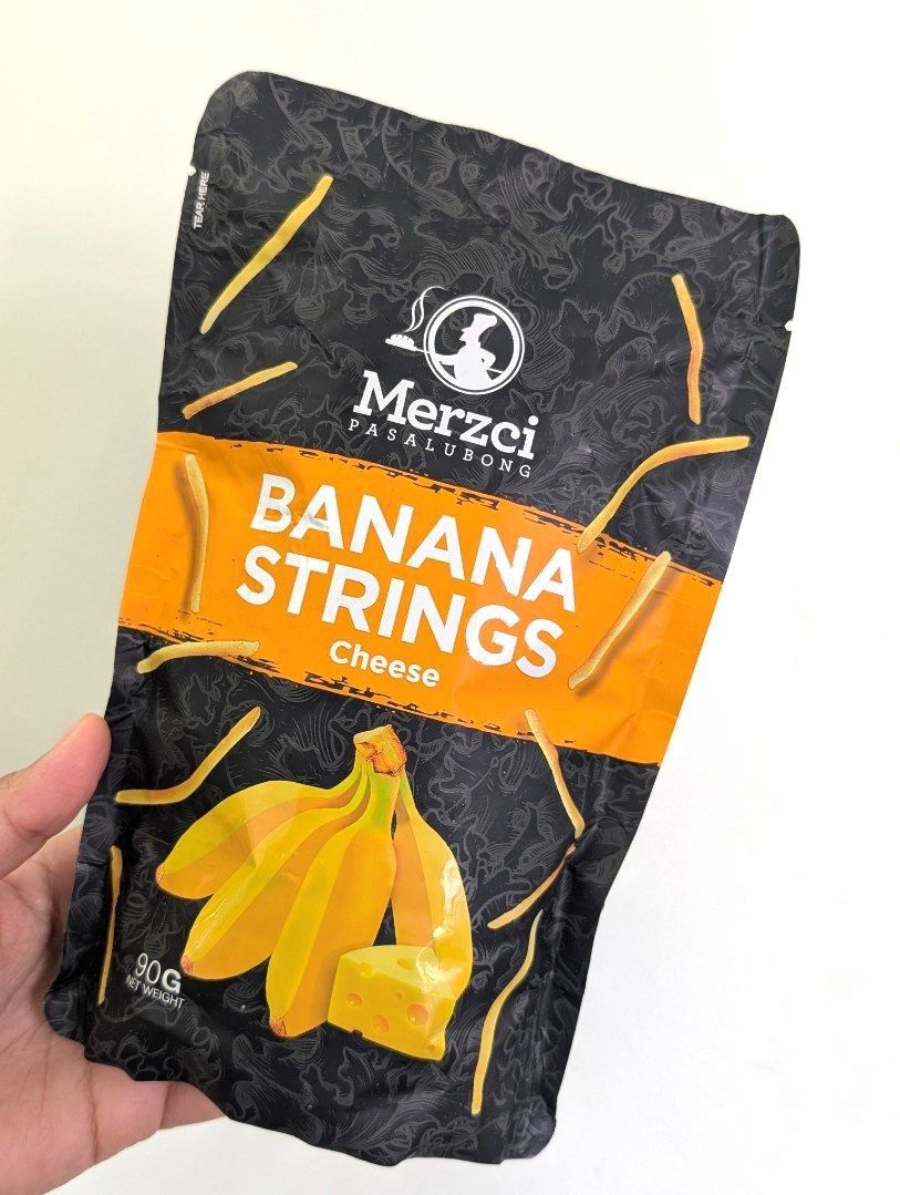 Banana Strings by Merzci (Category: Packaged & Instant Food) located in Makati City. Submitted by tiasetcetera (Listing ID 1337794219, Image 3). Description: Banana Strings by Merzci Pasalubong 📌 3 Flavors Available 🔸Sour Cream 🔸Cheese 🔸Barbeque Net Weight per pack : 90 grams Merzci is he trade name of CM&SONS FOOD PRODUCTS, INC. which was established in 1995. It is the leading bread and food pasalubong producer in Bacolod City and the island