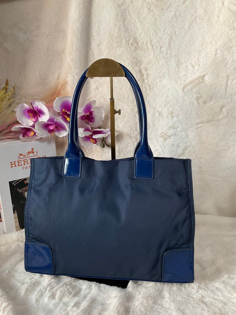 Preloved Tory Burch Ella Tote (Category: Luxury Bags & Wallets) located in La Trinidad. Submitted by naravincollections (Listing ID 1337902977, Image 2). Description: Dimensions: 24 cm(H) x 34 cm(L) x 12cm (W) Color: Blue/Navyblue, not faded,10/10 rate Hardware: Gold, 10\10 color rate Patent leather is still in very good condition, no cracks Nylon and cotton lining is still in excellent condition Some minor dirts still inside, looks washable nama