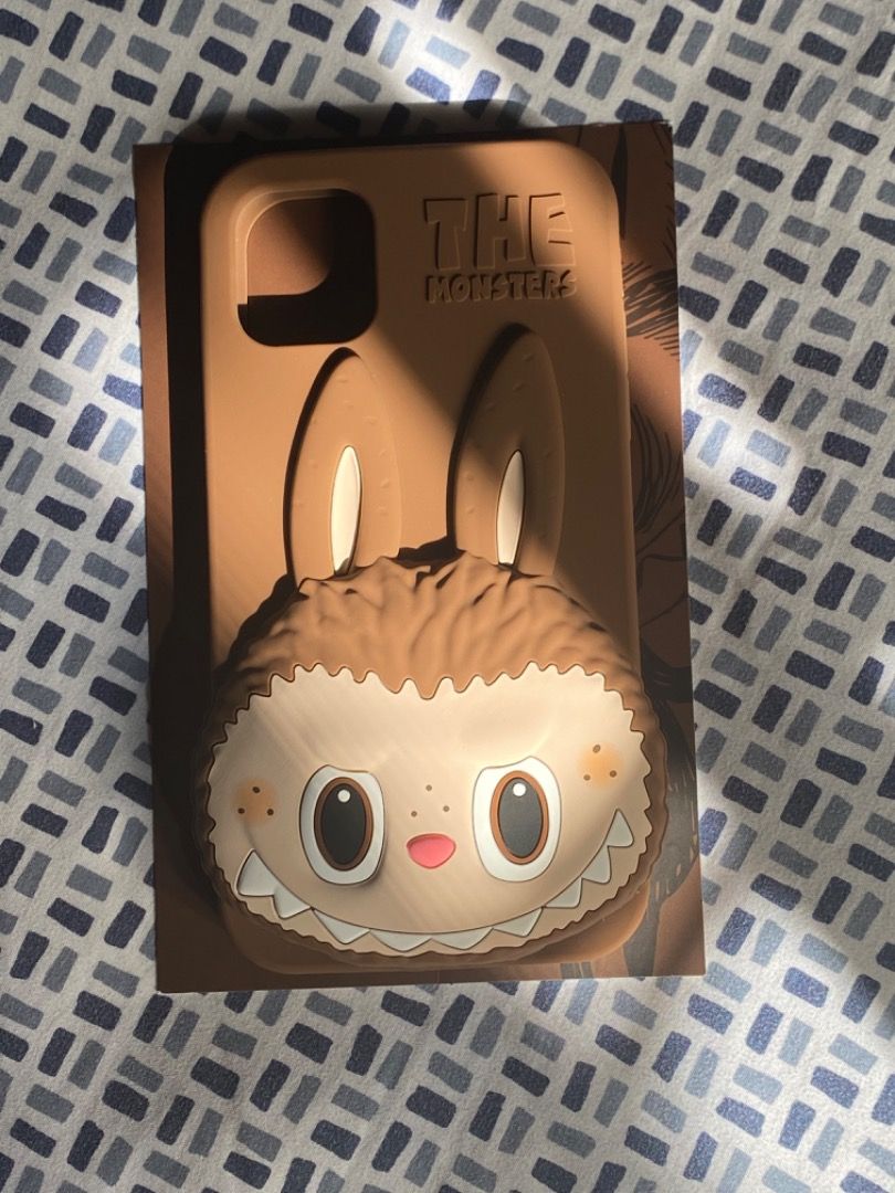 PopMart x HOW2WORK Brown Labubu Phone Case iPhone 11 (Category: Cases & Sleeves) located in Paranaque City. Submitted by kerropimarch (Listing ID 1337985560, Image 1). Description: bought from popmart store in the US, no box/plastic cover but with authenticity card for iPhone 11, silicone case m unused .