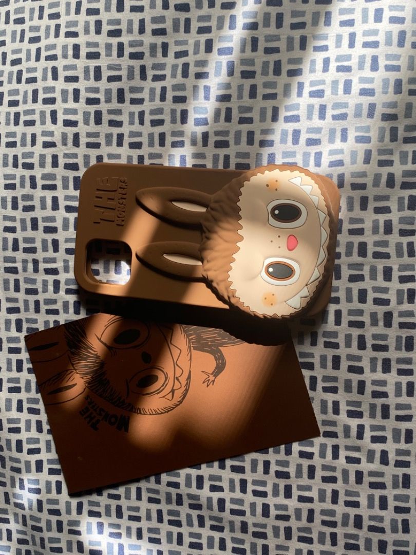 PopMart x HOW2WORK Brown Labubu Phone Case iPhone 11 (Category: Cases & Sleeves) located in Paranaque City. Submitted by kerropimarch (Listing ID 1337985560, Image 2). Description: bought from popmart store in the US, no box/plastic cover but with authenticity card for iPhone 11, silicone case m unused .