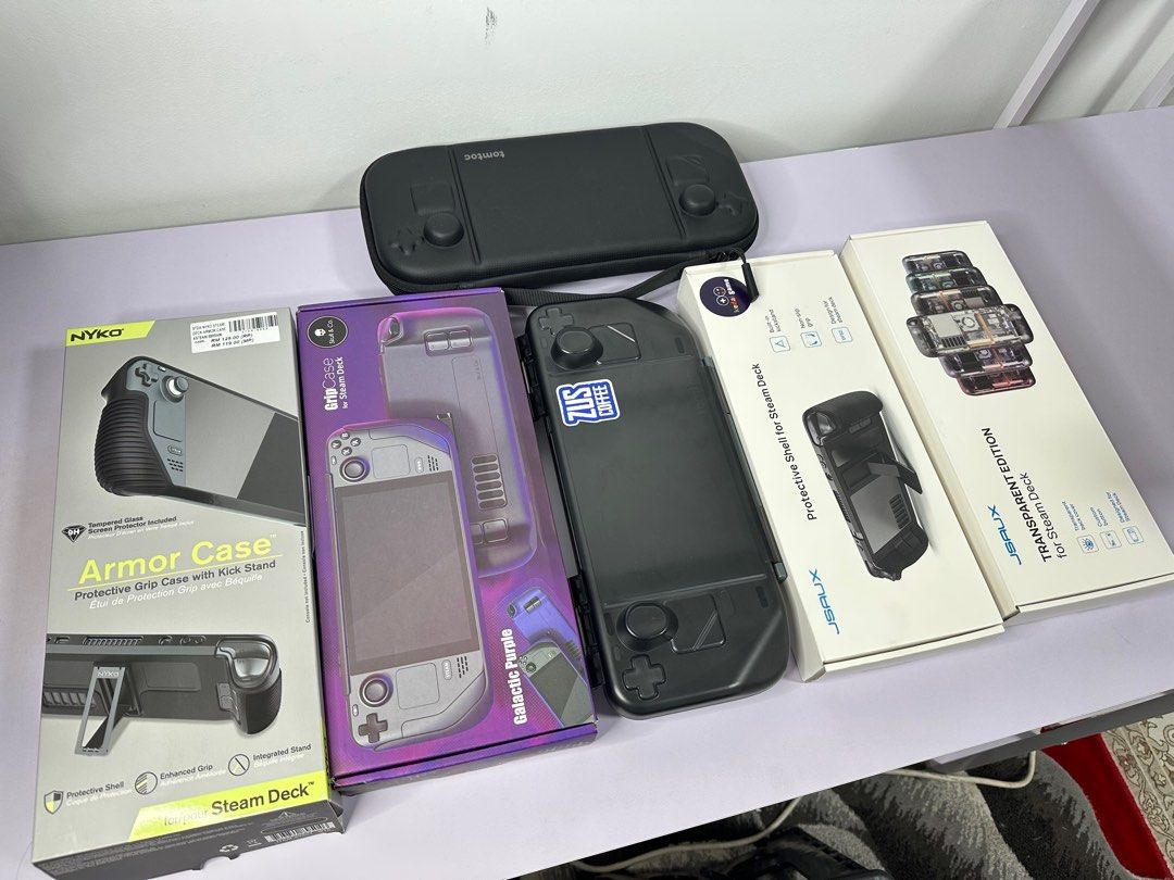 Various Steam Deck Cases (Category: Cases & Covers) located in Kuala Lumpur. Submitted by z4pz4p (Listing ID 1338933708, Image 1). Description: Steamdeck LCD/ Oled case 1. Tomtoc zip case SOLD 2. Tomtoc hard shell rm90 3. Jsaux case rm70 4. Jsaux backplate rm80 5. Nyko silicone case SOLD 6. SkullnCo Purple case rm70.