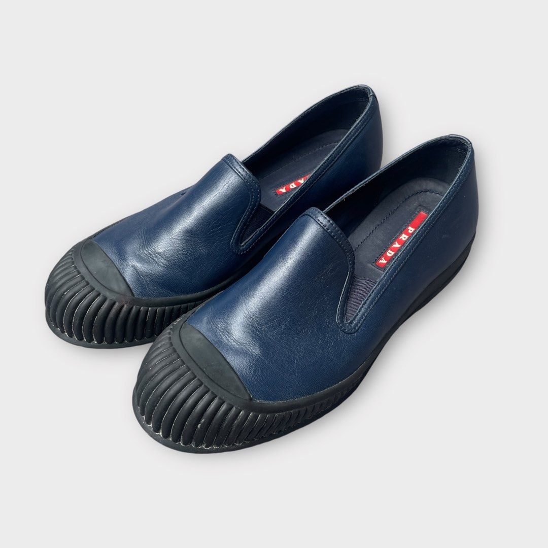 Prada - Military Navy Monolith Leather Slip-On Sneakers (Category: Sneakers) located in Los Banos. Submitted by declutterking (Listing ID 1333663411, Image 1). Description: Size 35.5 (Size 5 women) Good as new condition Pair only Authentic.