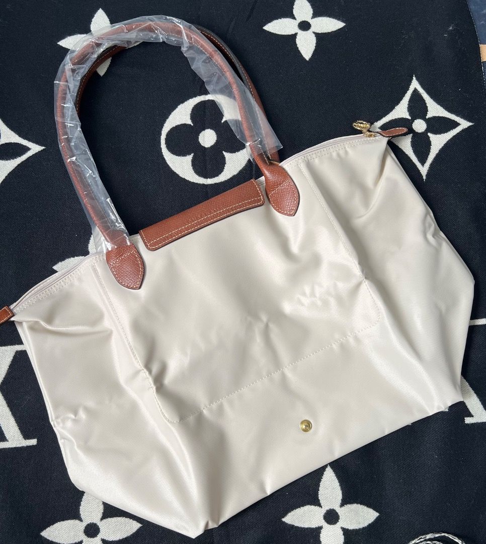 Longchamp Le Pliage Papier Large Tote Bag (Category: Luxury Bags & Wallets) located in Antipolo. Submitted by mjlenihcpreloved (Listing ID 1341191912, Image 2). Description: Longchamp Le Pliage Khaki Green Large Tote Dimensions : 31 cm (L - measured at the base of the bag) x 30 cm (H) x 19 cm (W) Material : Polyamide fabric with a minimum of 70% recycled fibers, with interior coating Metallic Hardware : gold color Closing : Zipper and snap closur