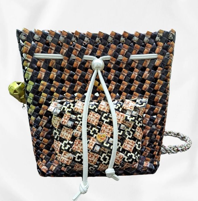 Cocoa Eclipse (Category: Backpacks) located in Singapore. Submitted by bcaresg (Listing ID 1342413809, Image 2). Description: Backpack with front pocket Dimensions: W: 28 cm, H: 28 cm This eye-catching backpack is handcrafted from recycled materials, featuring a unique woven design in black, brown, and tan. With a distinctive front pocket and drawstring closure, this bag is both stylish and sustainable. Perfect for everyday use and eco-conscious 