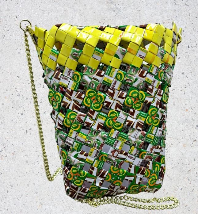 Milo Mate (Category: Cross-body Bags) located in Singapore. Submitted by bcaresg (Listing ID 1342532175, Image 2). Description: Small sling bag with divider made with recycled materials Dimensions: W: 13 cm, H: 19 cm This unique sling bag is handcrafted from recycled materials, featuring a vibrant green, white, and brown woven design. The interior divider helps keep your belongings organized, and the chain strap adds a stylish touch. This bag is 