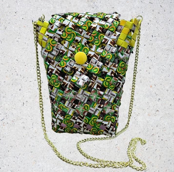 Milo Mate (Category: Cross-body Bags) located in Singapore. Submitted by bcaresg (Listing ID 1342532175, Image 1). Description: Small sling bag with divider made with recycled materials Dimensions: W: 13 cm, H: 19 cm This unique sling bag is handcrafted from recycled materials, featuring a vibrant green, white, and brown woven design. The interior divider helps keep your belongings organized, and the chain strap adds a stylish touch. This bag is 