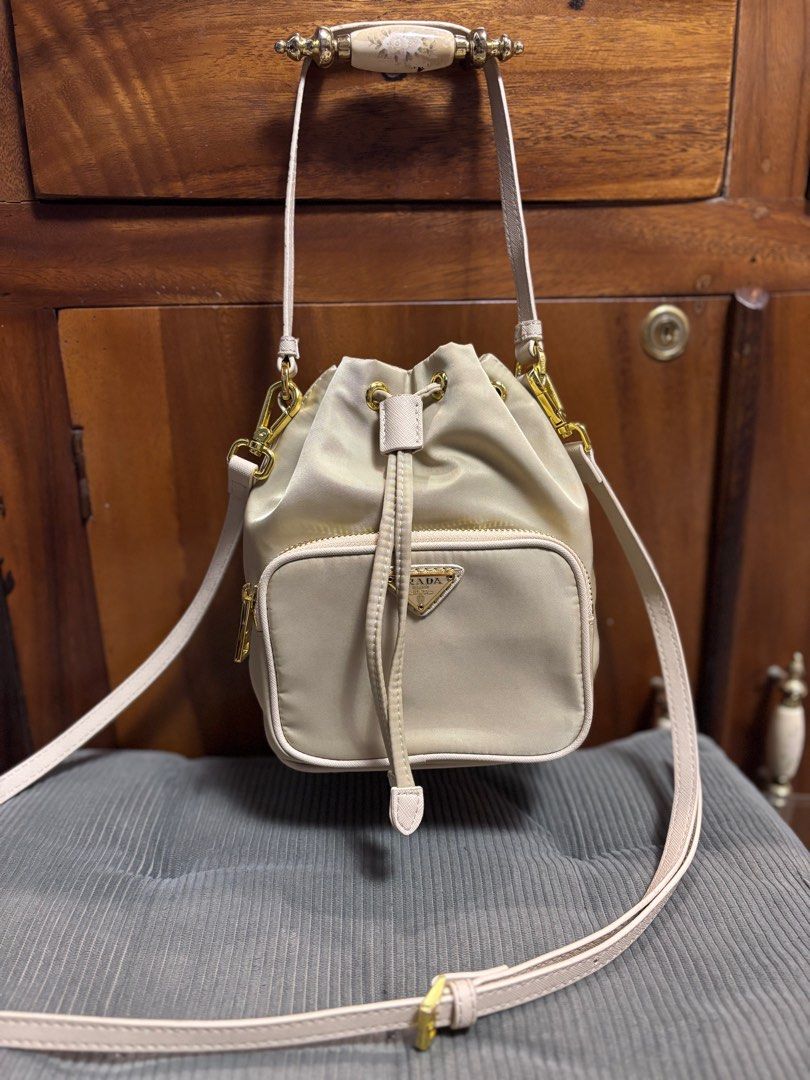 Preloved Prada small bucket (Category: Luxury Bags & Wallets) located in Imus. Submitted by bagsofblessings24 (Listing ID 1343156089, Image 1). Description: Preloved Prada small bucket bag 2way handbag and sling/shoulder/croosbody Length 6in x Height 7.5in Light beige, nylon Minimal signs of use on the body With tag Self authentication With free dust bag Pm for any questions.