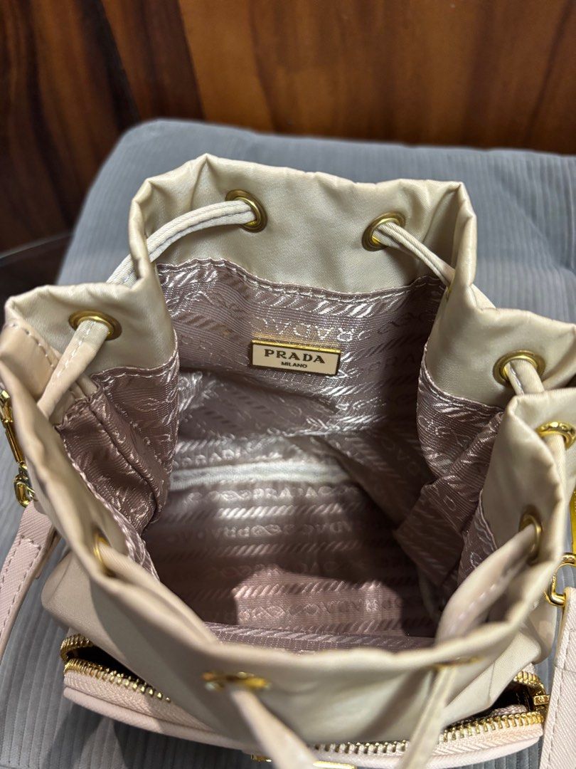 Preloved Prada small bucket (Category: Luxury Bags & Wallets) located in Imus. Submitted by bagsofblessings24 (Listing ID 1343156089, Image 3). Description: Preloved Prada small bucket bag 2way handbag and sling/shoulder/croosbody Length 6in x Height 7.5in Light beige, nylon Minimal signs of use on the body With tag Self authentication With free dust bag Pm for any questions.