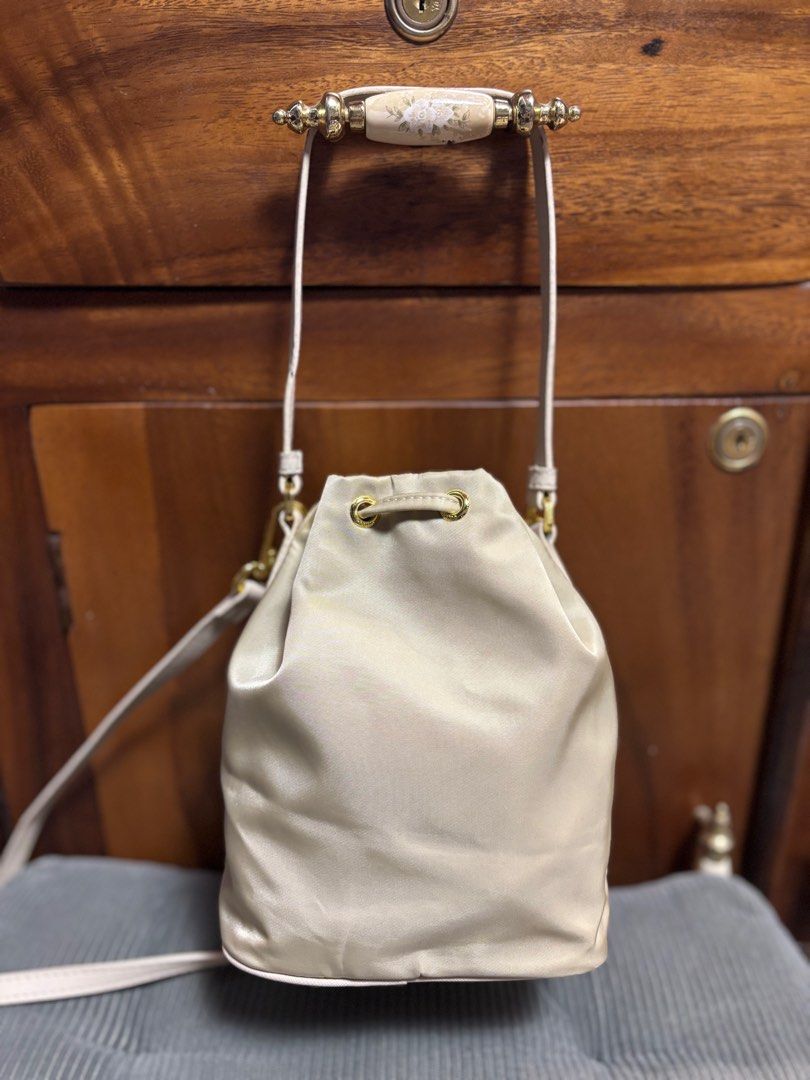Preloved Prada small bucket (Category: Luxury Bags & Wallets) located in Imus. Submitted by bagsofblessings24 (Listing ID 1343156089, Image 2). Description: Preloved Prada small bucket bag 2way handbag and sling/shoulder/croosbody Length 6in x Height 7.5in Light beige, nylon Minimal signs of use on the body With tag Self authentication With free dust bag Pm for any questions.