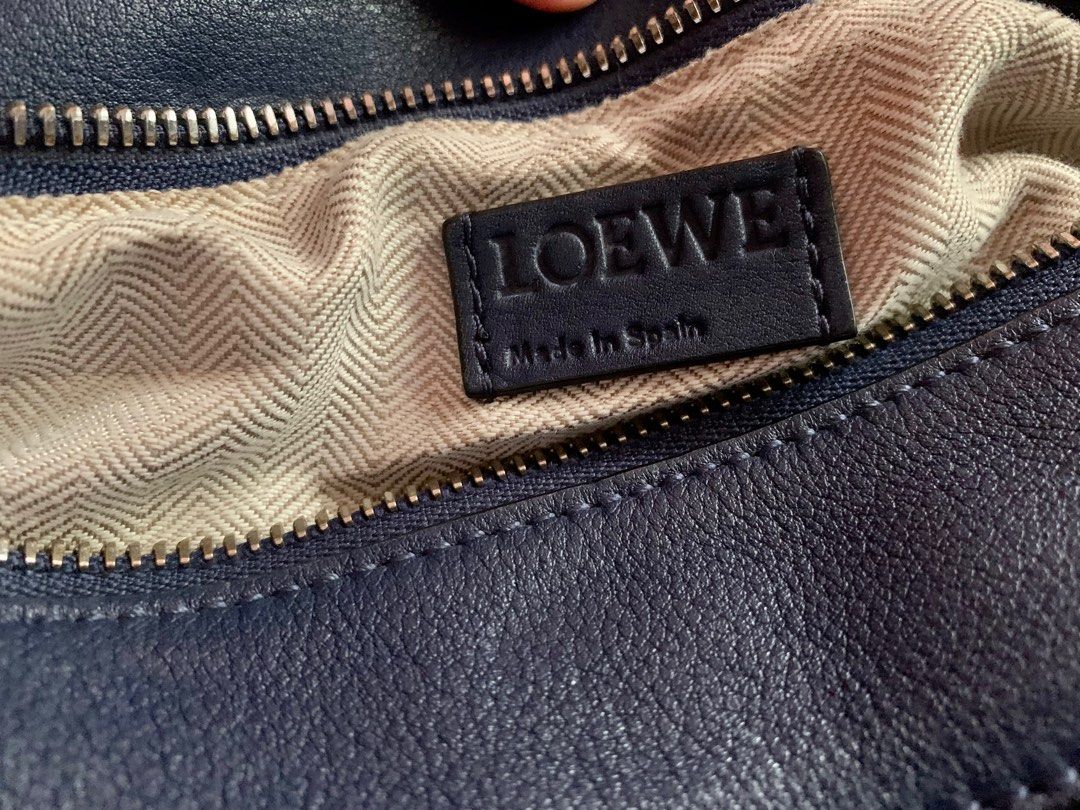 Loewe Puzzle bag (Medium) (Category: Luxury Bags & Wallets) located in Davao. Submitted by chirella17 (Listing ID 1344219972, Image 3). Description: genuine leather silver-tone hardware color navy blue detachable/adjustable strap embossed anagram logo -Shows normal signs of use including internal wear, oxidation, scratches or marks on surface and hardware. This bag is in good pre-owned condition..