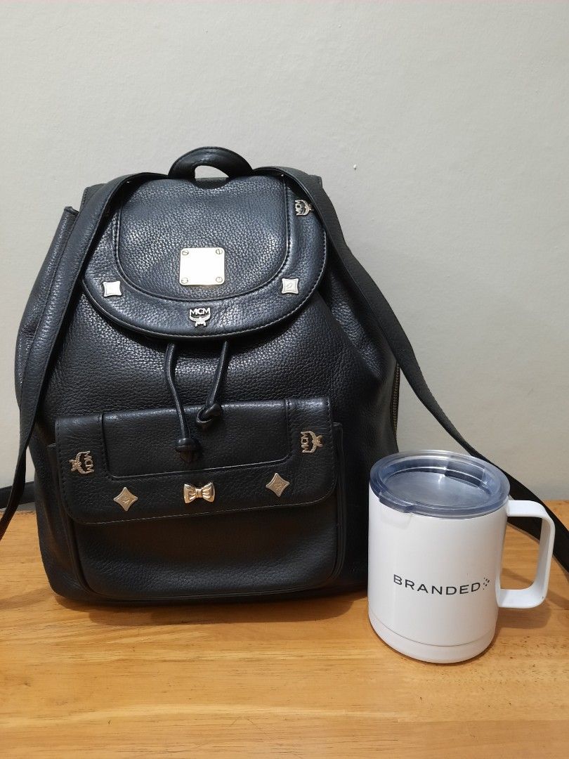 MCM Backpack Leather Germany (Category: Luxury Bags & Wallets) located in Valenzuela. Submitted by one.touch (Listing ID 1344200864, Image 1). Description: 👜MCM BACKPACK 👜BLACK LEATHER w/ GOLD STUDS ✅PRELOVED/USED ✅Good Condition ✅Few tarnish on hardware ✅Very Good Leather Condition ✅Medium size 13x12 inches ✅Draw String Clousure ✅Shoulder Leather Strap ✅Canvass lining 📍Loc: Valenzuela City 🛵Courier: LBC/Lalamove/J&T 💸Payment First 🚫No COD.
