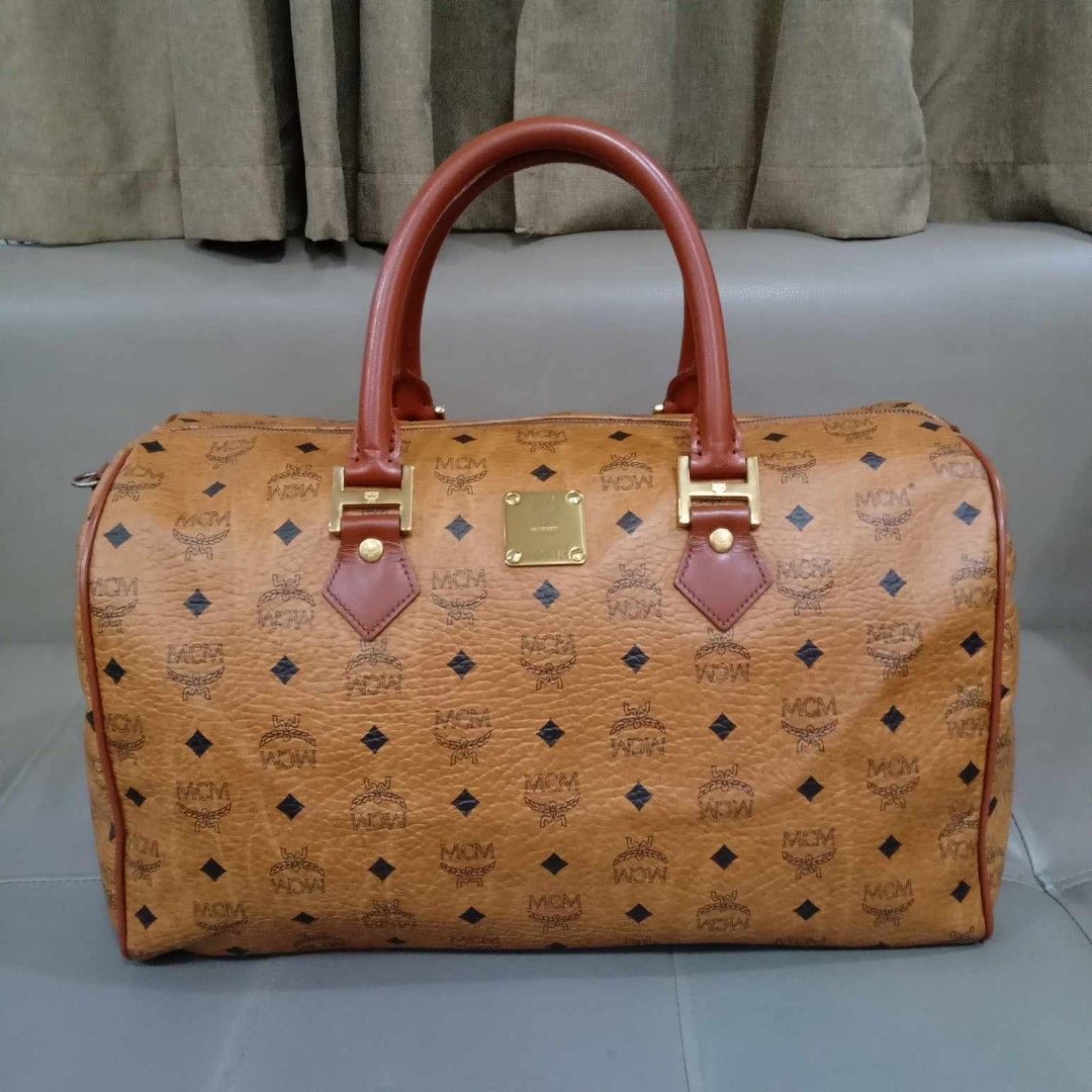 MCM Cognac Boston Travel Bag 40 (Category: Luxury Bags & Wallets) located in Taguig. Submitted by esa.agustin (Listing ID 1339601073, Image 2). Description: Original MCM Cognac monogram boston travel bag. Size 40 cm. With original strap. Made in Germany..