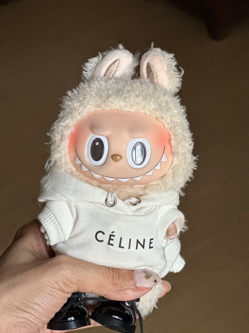 Labubu V1 (Soymilk ) (Category: Designer & Blind Box Toys) located in Antipolo. Submitted by ivychillz (Listing ID 1344509078, Image 2). Description: Selling my Labubu Soymilk with Celine Apparel. Doll only. The card is misplaced :( No more box & foil too Check second photo the eyebrows have a bit of a stain but not that noticeable. Been hiding it so I bought the Celine beanie. RFS: Losing sparks for my collectibles .