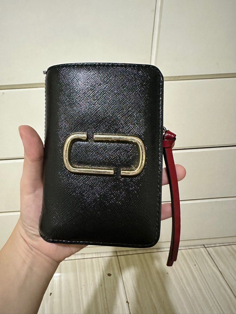 Marc Jacobs Snap Wallet (Category: Wallets & Card holders) located in Manila. Submitted by hapishopee (Listing ID 1286155135, Image 1). Description: With hairline scratches and slight discoloration on the iconic hardwares. The snap button is a bit loose. The rubber lining on one side is a bit off but can be mended..
