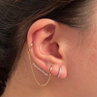 Two hoop piercing jewelry earrings with chain in 18k gold setting