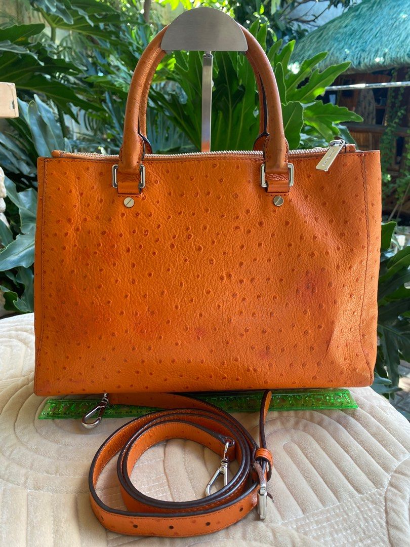 MICHAEL KORS 2-Way Bag (Category: Luxury Bags & Wallets) located in Baliuag. Submitted by nylinel (Listing ID 1287552834, Image 3). Description: Material in orange ostrich leather Hardware in silver tone Size: L- 12.5” x H- 9” x W- 4” Guaranteed Original 💯 Outside in very good condition Inside with leather stains on zipper side.