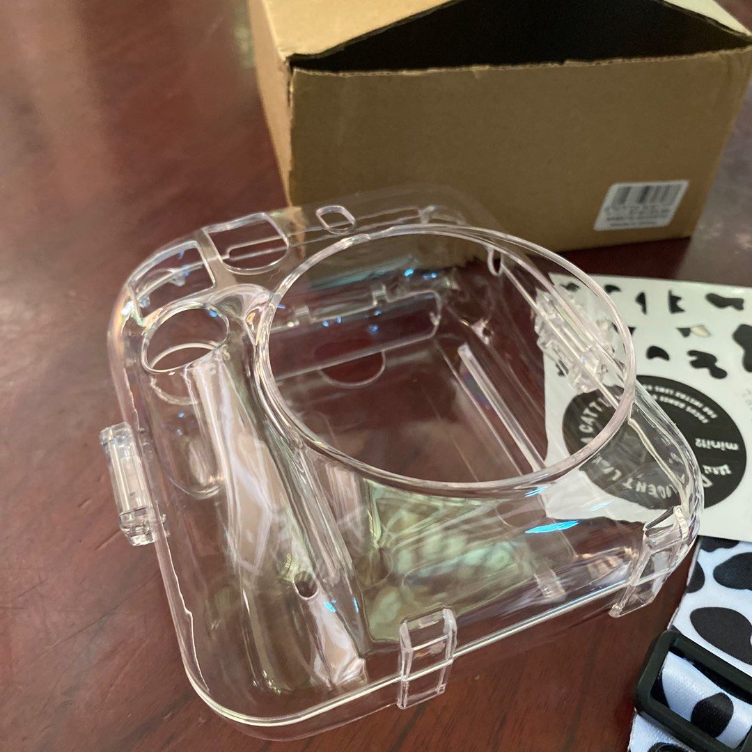 Instax Mini 12 Case Clear with strap and stickers (Category: Camera Bags & Carriers) located in Asingan. Submitted by apple_daisy (Listing ID 1285078426, Image 2). Description: For sale! Instax Mini 12 Case Clear with strap and stickers - Comes with a box - Never used - Bought for ₱ 210 - Selling for ₱ 130.